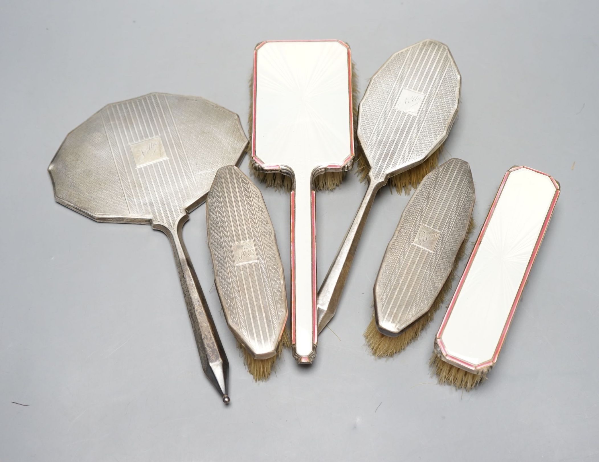 Two 1950's silver and enamel mounted brushes and an earlier four piece silver mounted brush set.